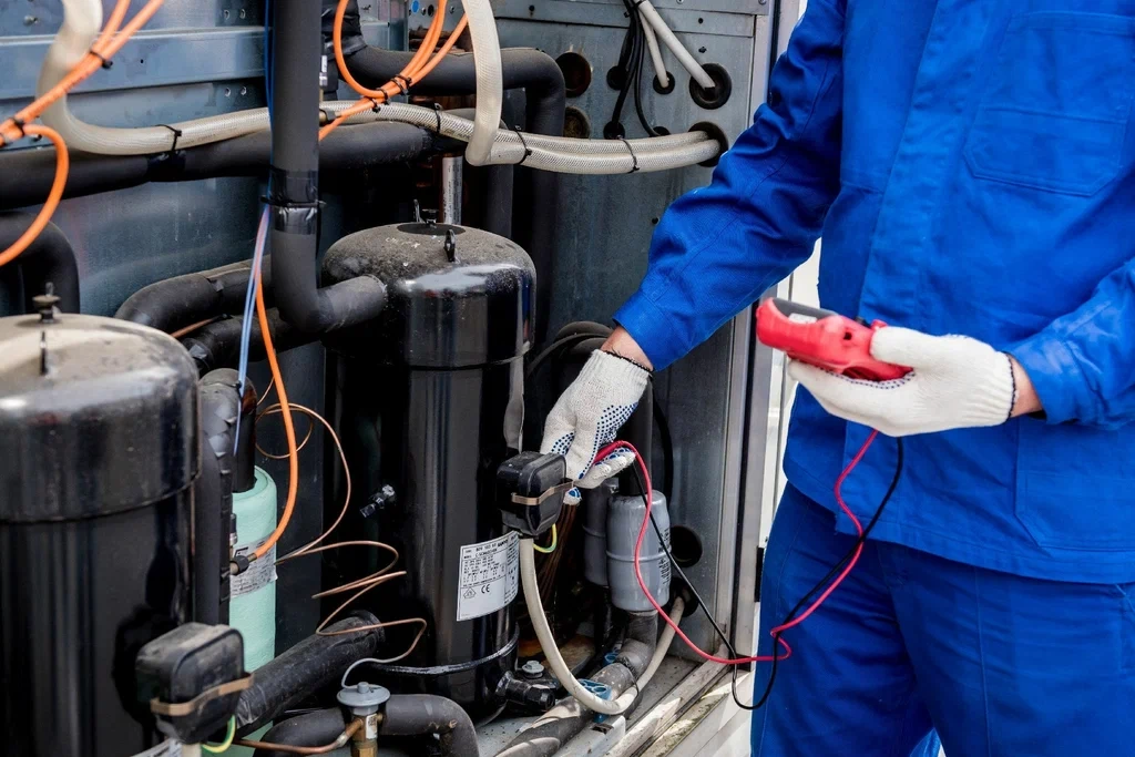 expert frigoriste certifié F-Gas, réalisant la maintenance d'une pompe à chaleur en Brabant Wallon